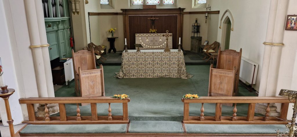 The front of St Mary's Rawmarsh church, freshly cleaned. There is an alter in the background and 2 chairs and communion rails in the foreground.